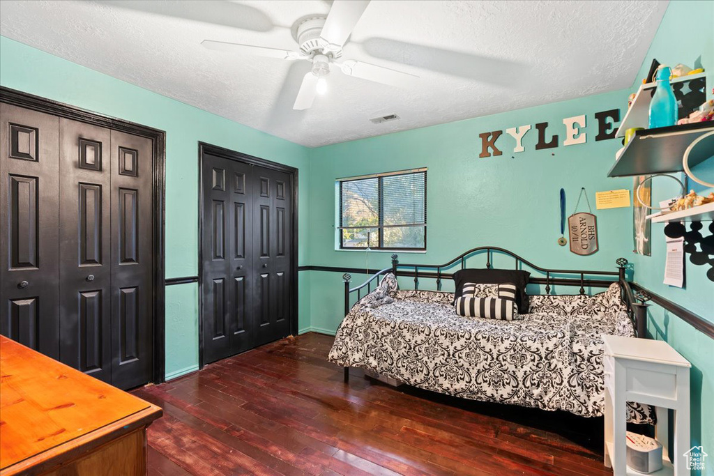 Bedroom featuring dark wood-type flooring, ceiling fan, and a textured ceiling