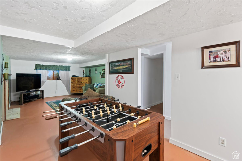 Rec room featuring concrete floors and a textured ceiling