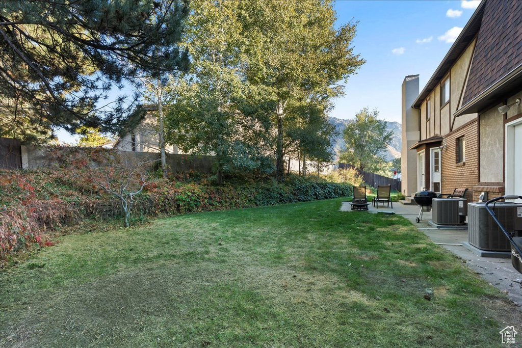 View of yard with a patio and central AC unit