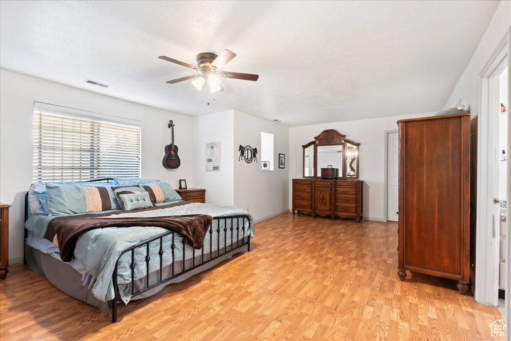 Bedroom with ceiling fan and light wood-type flooring