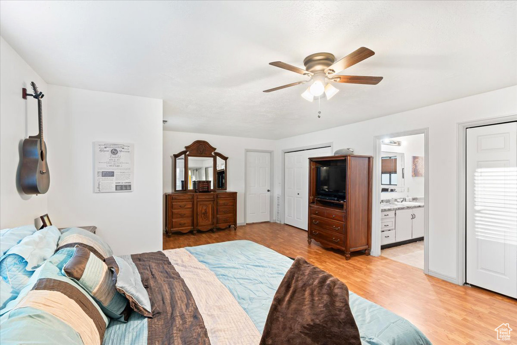 Bedroom featuring light hardwood / wood-style flooring, connected bathroom, and ceiling fan