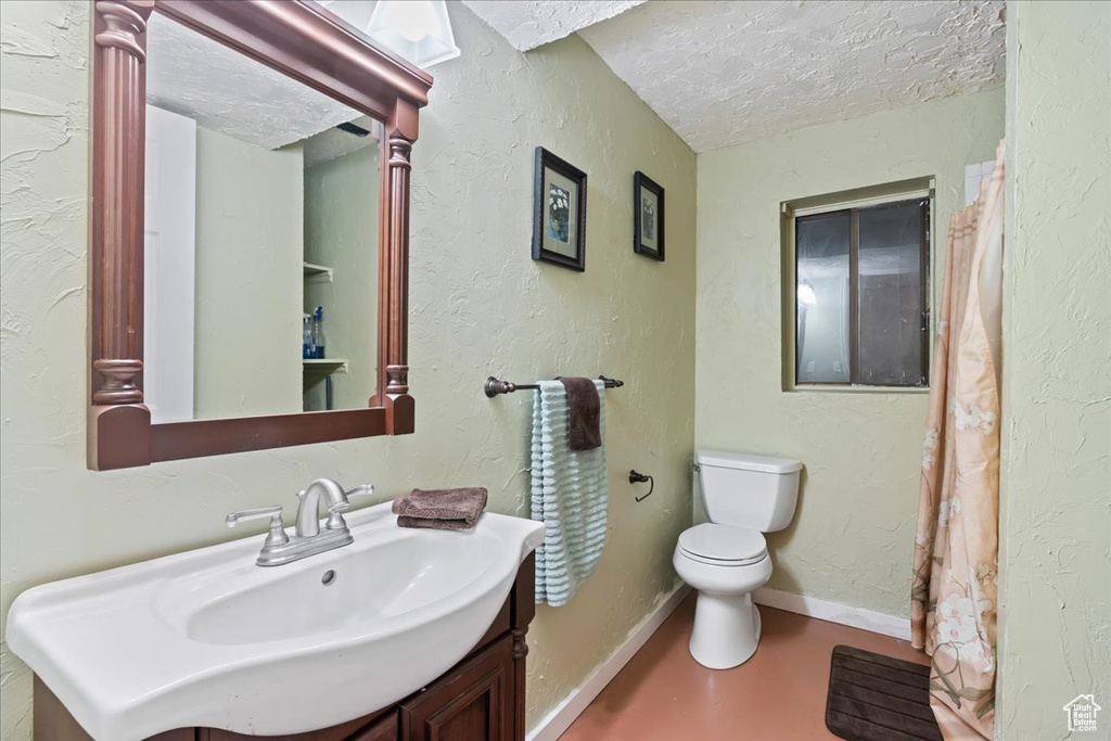 Bathroom with toilet, a textured ceiling, and vanity