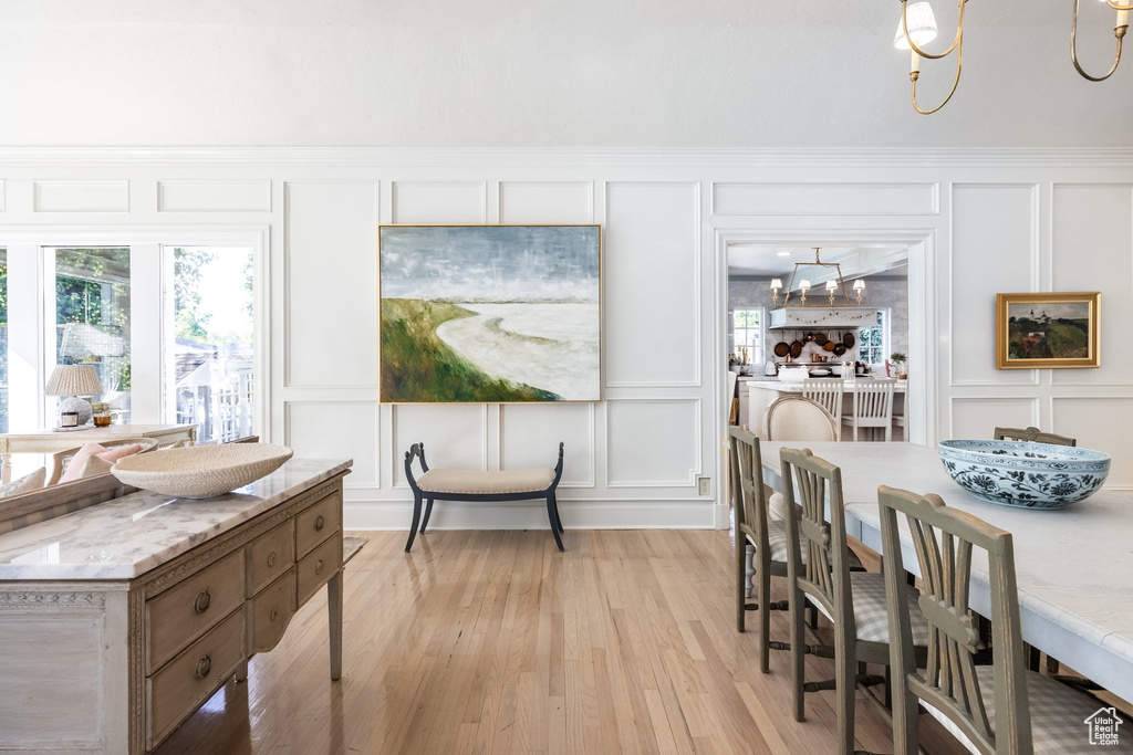 Dining space featuring a notable chandelier and light wood-type flooring