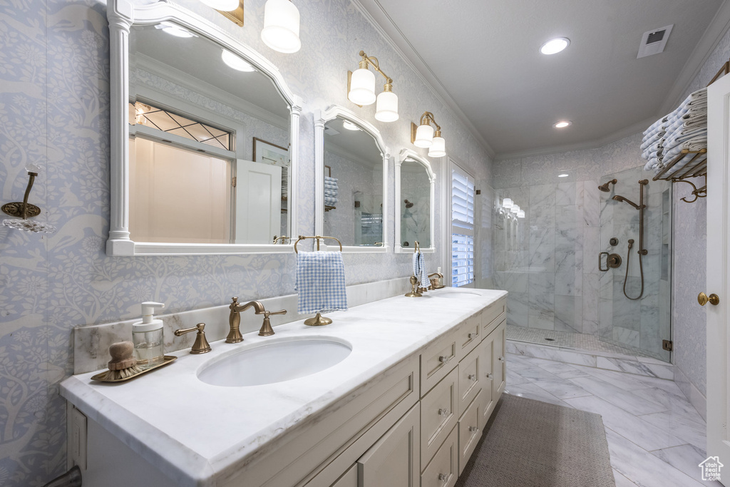 Bathroom featuring vanity, ornamental molding, and a tile shower