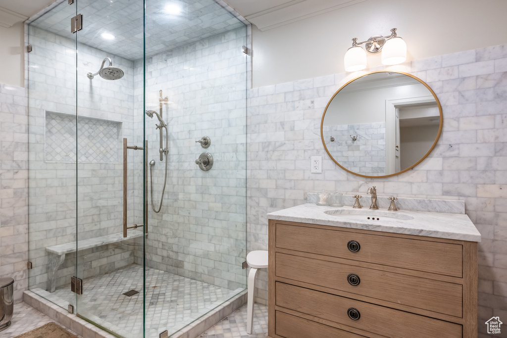 Bathroom featuring vanity and tile walls