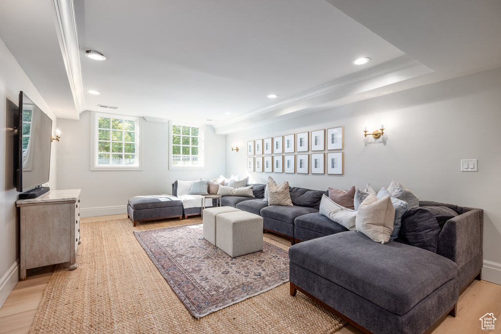 Living room with light hardwood / wood-style floors and crown molding