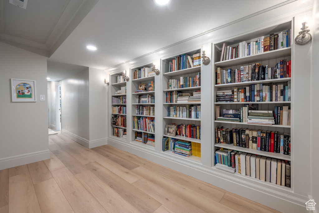 Corridor featuring light hardwood / wood-style flooring and crown molding