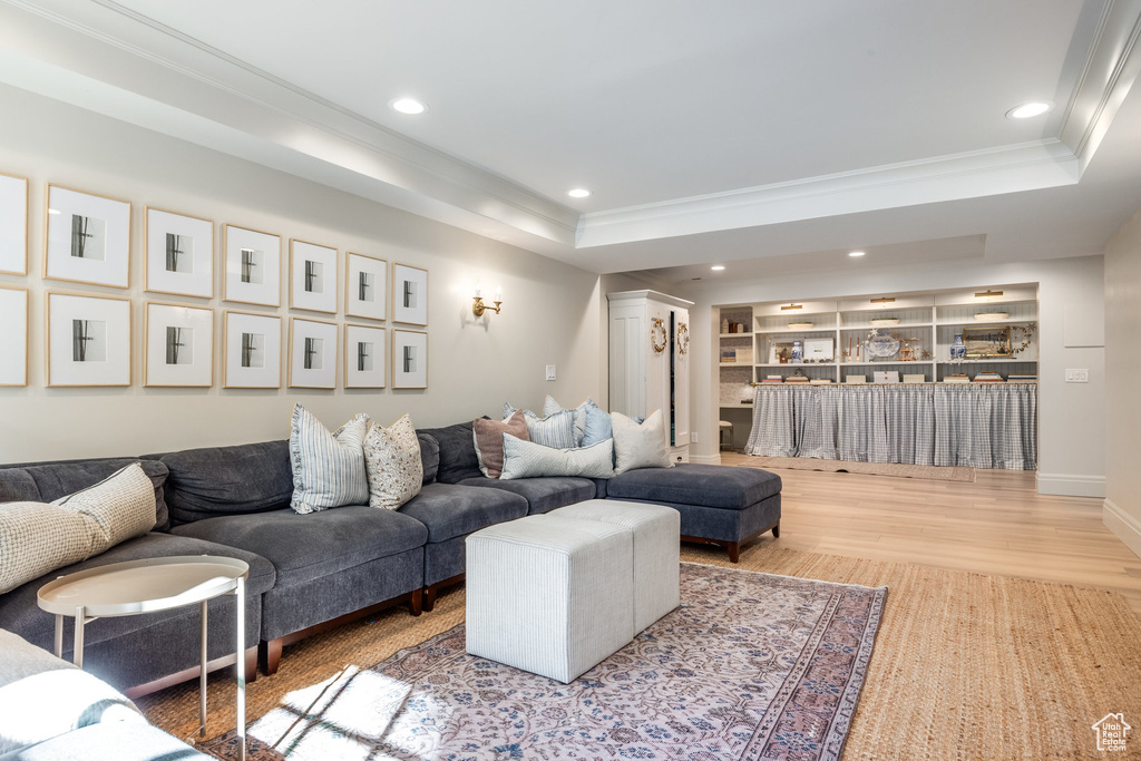 Living room featuring ornamental molding, a tray ceiling, and hardwood / wood-style flooring