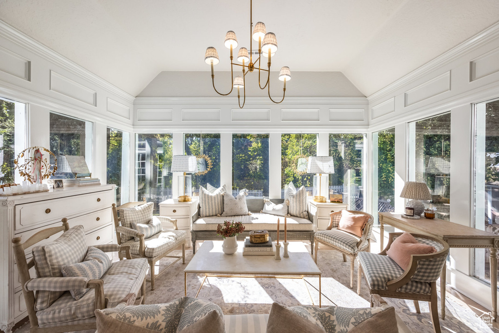 Sunroom / solarium with a notable chandelier, lofted ceiling, and a wealth of natural light