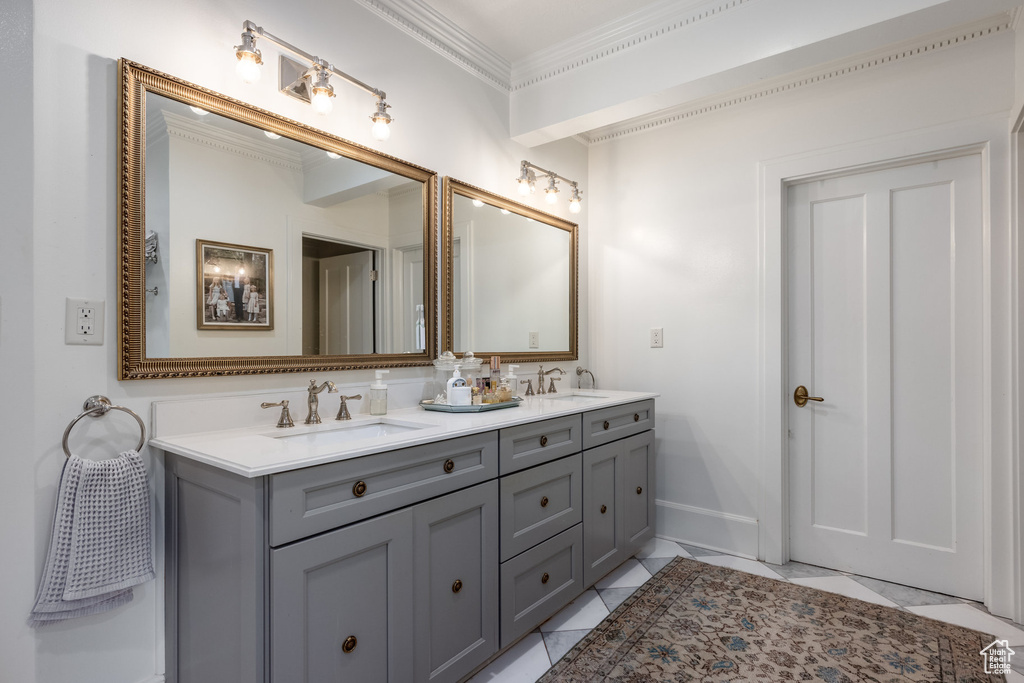 Bathroom featuring vanity, ornamental molding, and tile patterned flooring