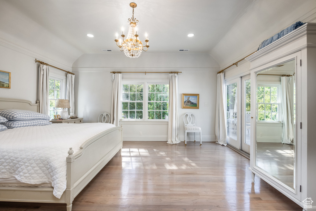 Bedroom featuring a notable chandelier, access to outside, vaulted ceiling, and light wood-type flooring