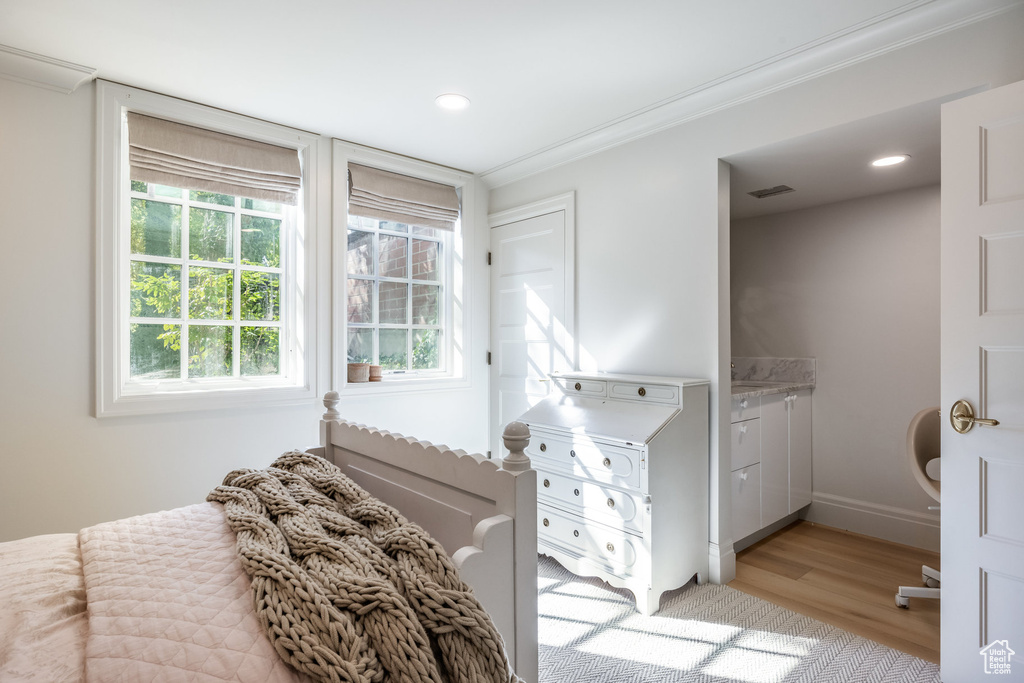 Bedroom featuring ornamental molding and light wood-type flooring