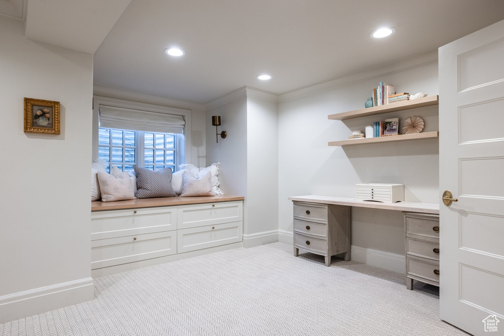 Office featuring built in desk, ornamental molding, and light colored carpet