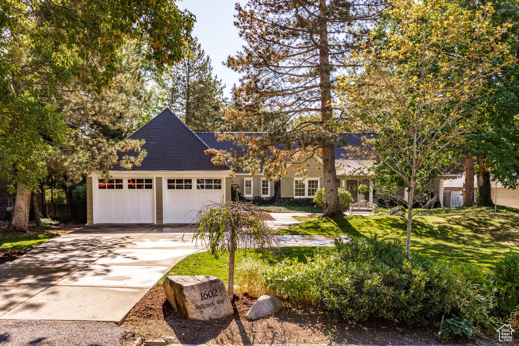 View of front facade with a garage and a front lawn