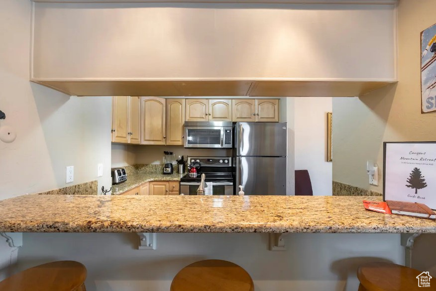 Kitchen featuring a breakfast bar, stainless steel appliances, and kitchen peninsula