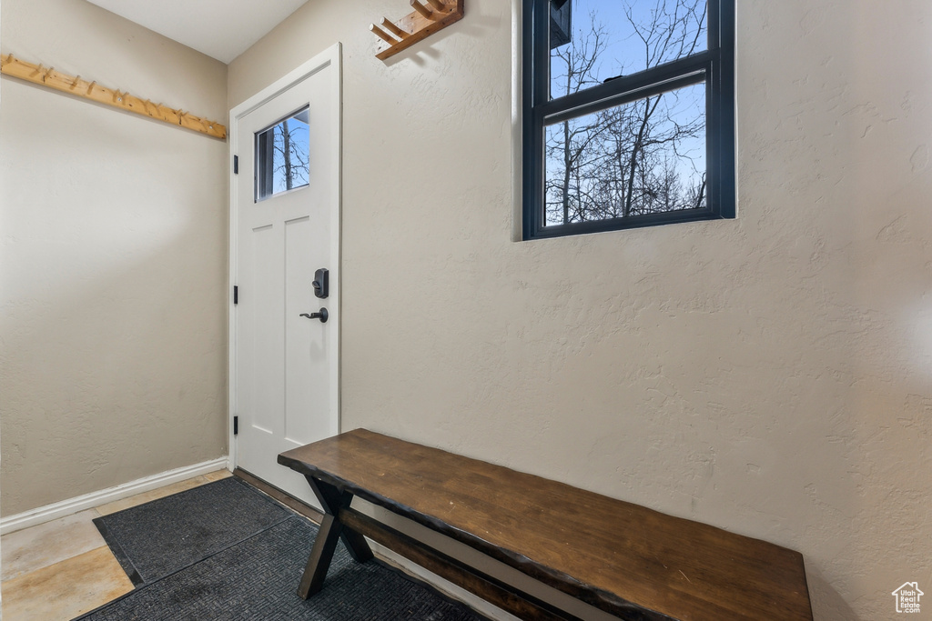 Foyer with a textured wall and baseboards