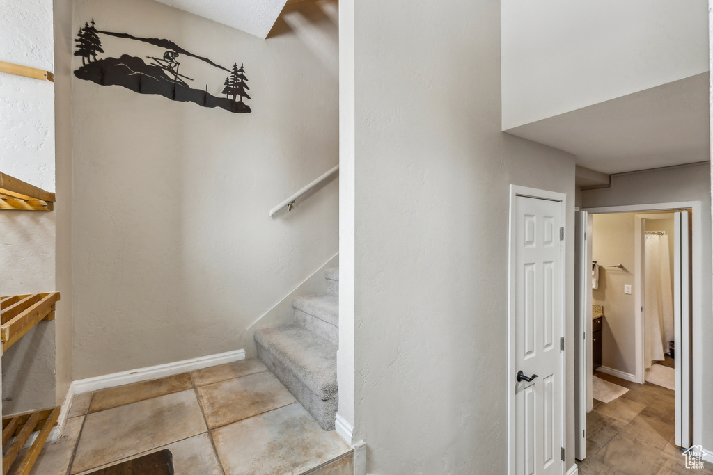 Staircase featuring tile patterned flooring and baseboards