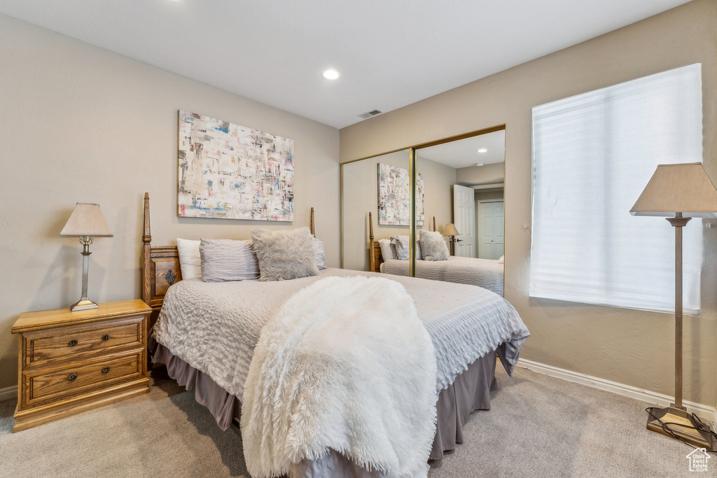 Bedroom with visible vents, baseboards, light carpet, recessed lighting, and a closet