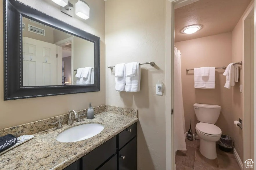 Bathroom featuring vanity, toilet, and tile patterned floors