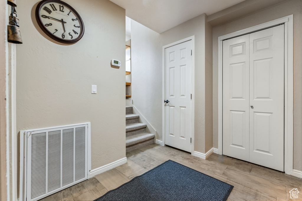 Entryway with visible vents, stairway, baseboards, and wood finished floors