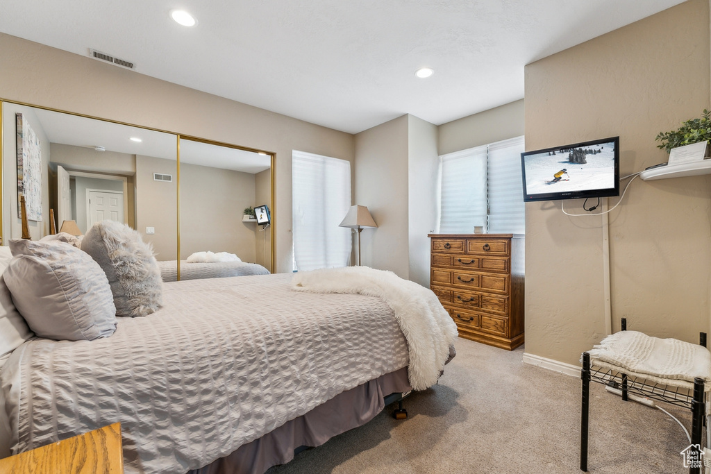 Bedroom with recessed lighting, visible vents, a closet, and light carpet