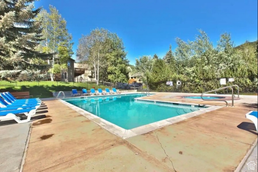 Community pool featuring a patio and a hot tub
