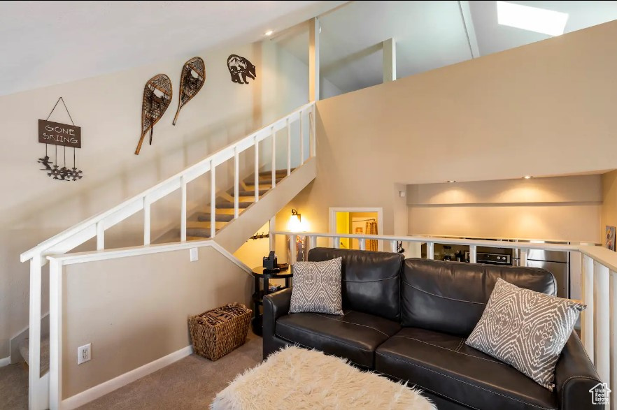 Living room featuring high vaulted ceiling and carpet