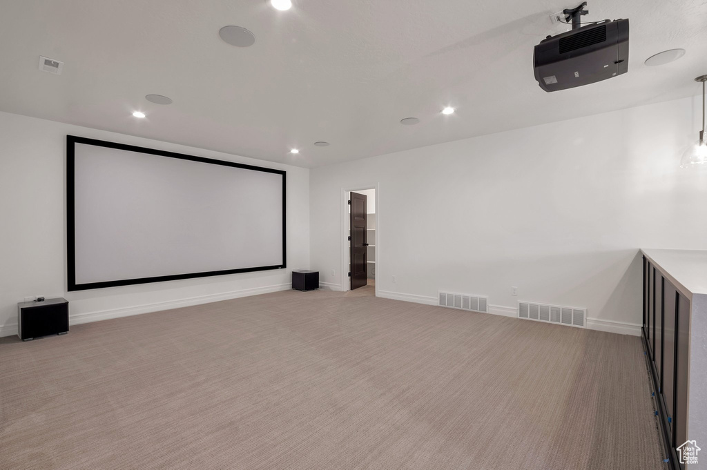 Home theater room featuring light carpet