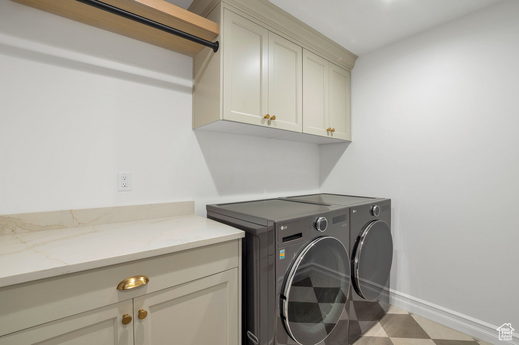 Laundry area featuring cabinets and washer and clothes dryer