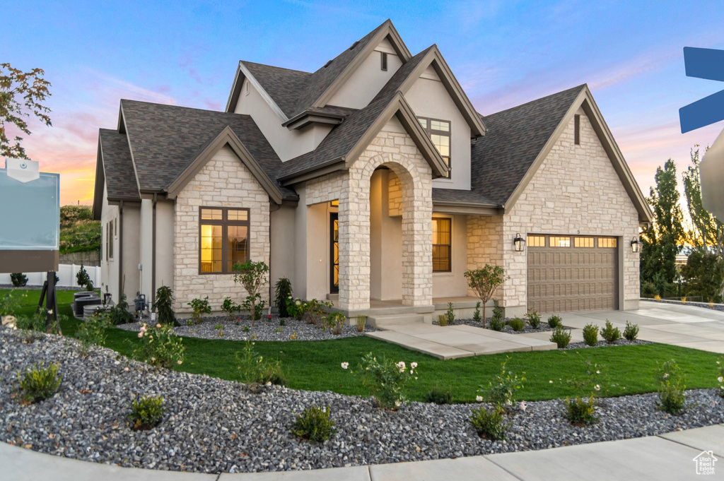 View of front of house with a yard and a garage