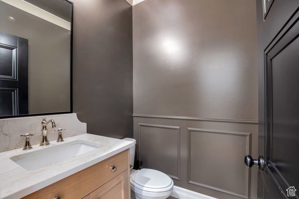 Bathroom featuring backsplash, vanity, and toilet