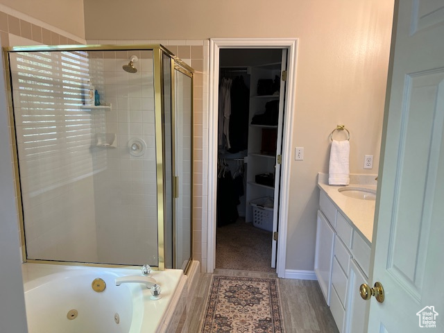 Bathroom with vanity, separate shower and tub, and hardwood / wood-style floors