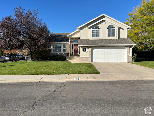 View of front facade with a front lawn and a garage