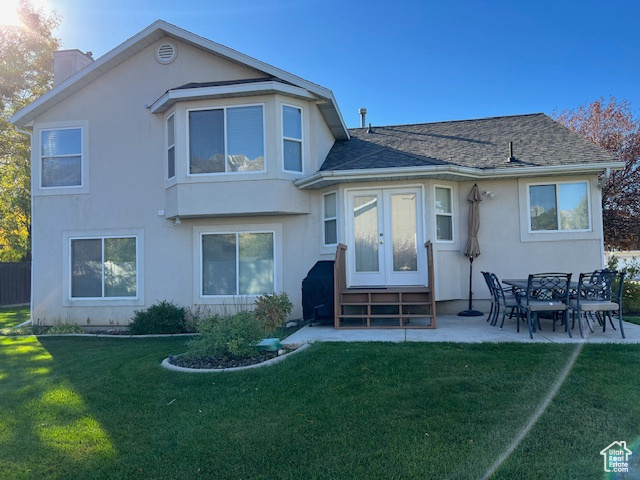 Rear view of property with a patio and a lawn