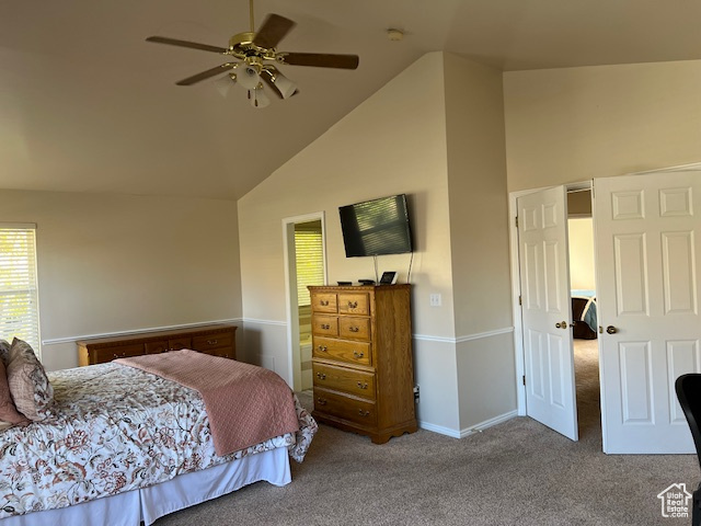 Carpeted bedroom with vaulted ceiling and ceiling fan