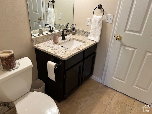 Bathroom featuring vanity, toilet, and tile patterned flooring