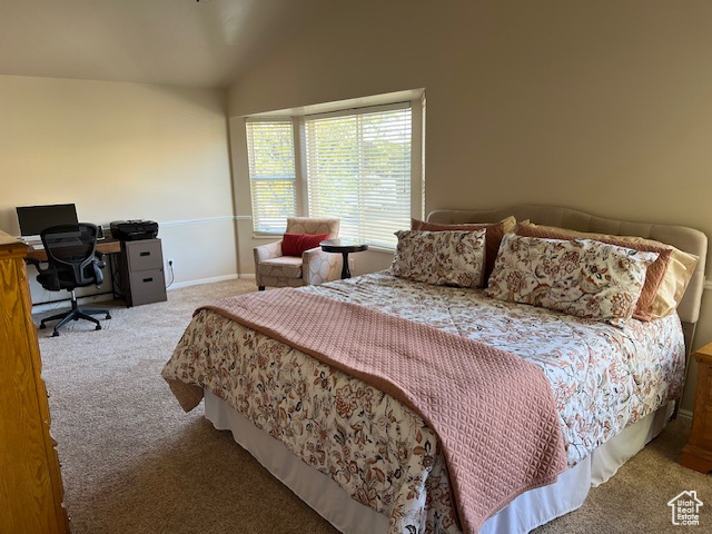 Bedroom featuring lofted ceiling and carpet flooring