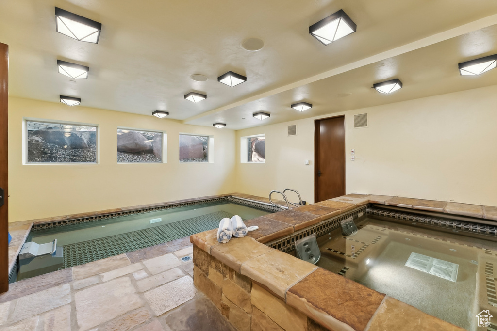 View of swimming pool with an indoor hot tub