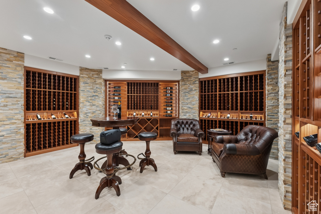 Wine cellar featuring beam ceiling