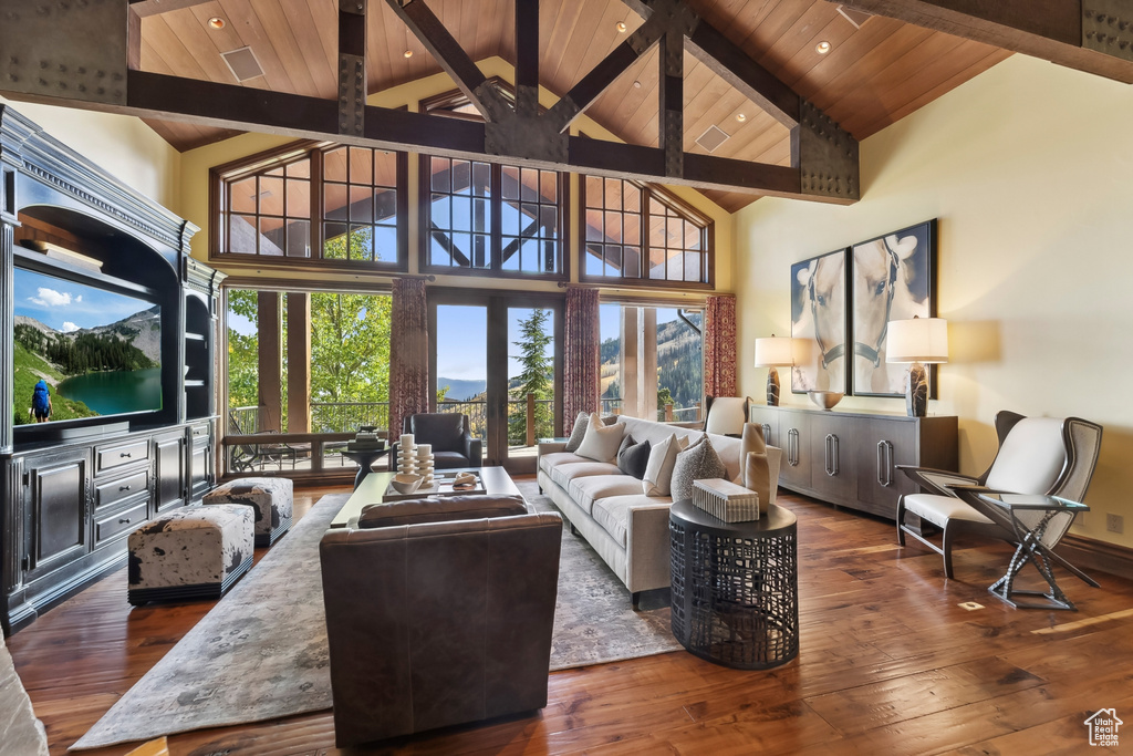 Living room with dark wood-type flooring, high vaulted ceiling, wooden ceiling, and a wealth of natural light