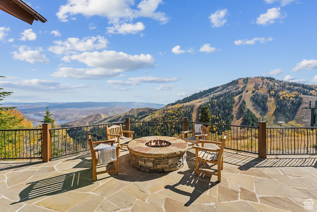 View of patio with a mountain view and a fire pit