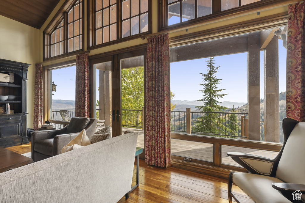 Living room featuring a mountain view, hardwood / wood-style flooring, high vaulted ceiling, and wooden ceiling