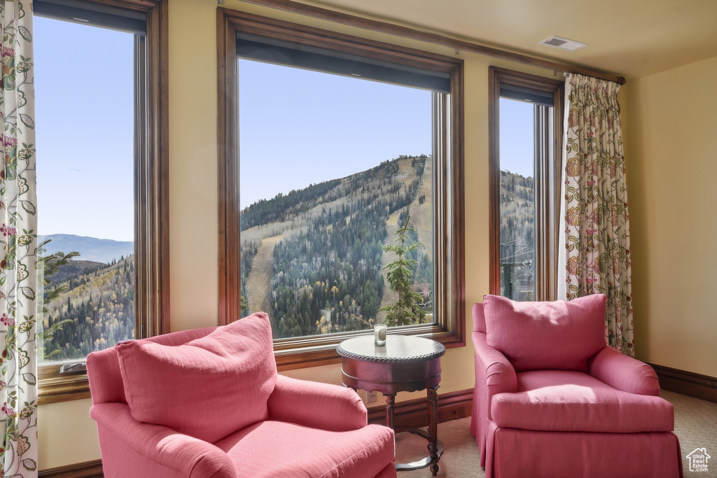 Sitting room featuring carpet and a mountain view