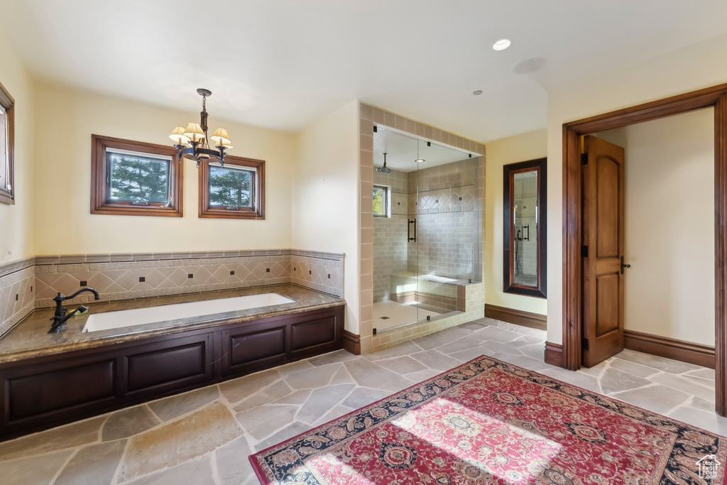 Bathroom featuring a notable chandelier and plus walk in shower