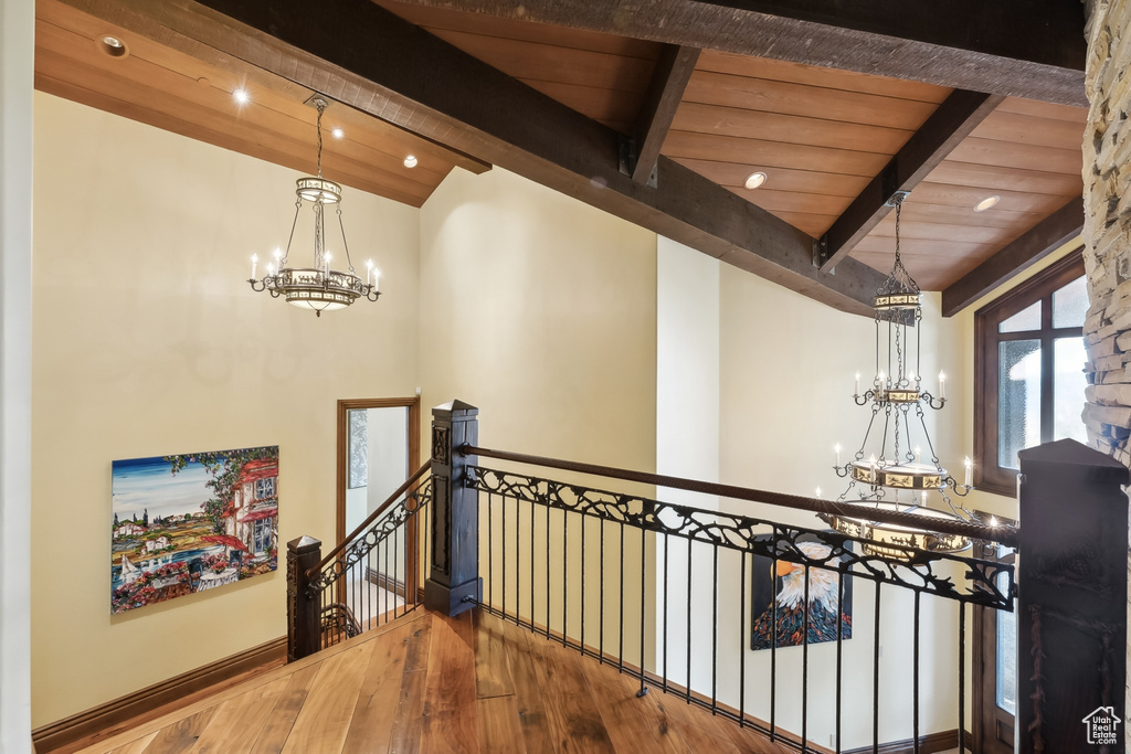 Corridor with a notable chandelier, wood ceiling, hardwood / wood-style flooring, and beamed ceiling