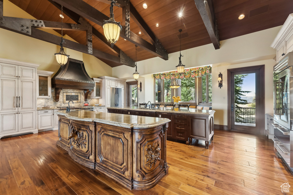 Kitchen with a large island, high vaulted ceiling, hardwood / wood-style flooring, and wood ceiling