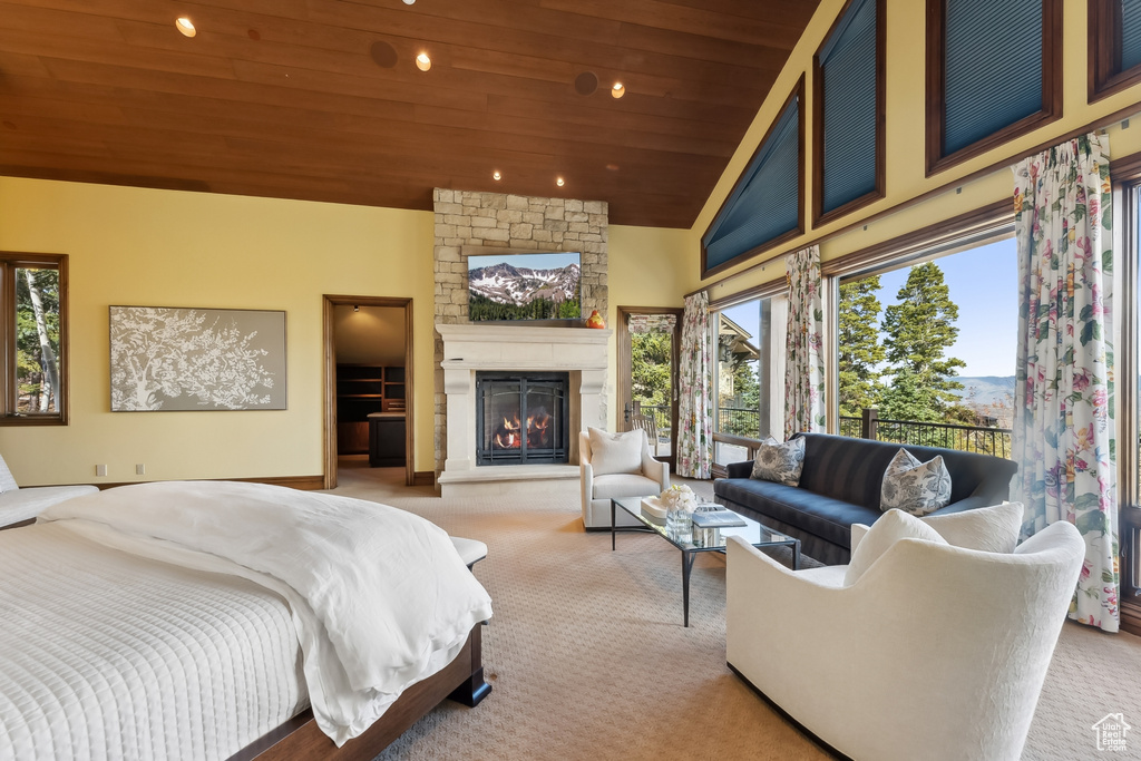 Carpeted bedroom featuring high vaulted ceiling, wooden ceiling, multiple windows, and a fireplace