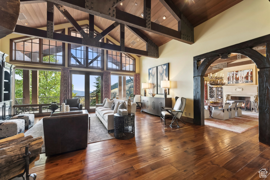 Living room with high vaulted ceiling, wooden ceiling, dark hardwood / wood-style flooring, and plenty of natural light