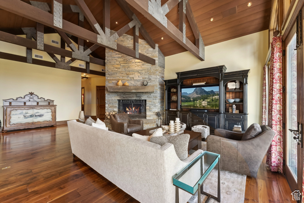 Living room featuring a stone fireplace, wood ceiling, high vaulted ceiling, and dark hardwood / wood-style flooring