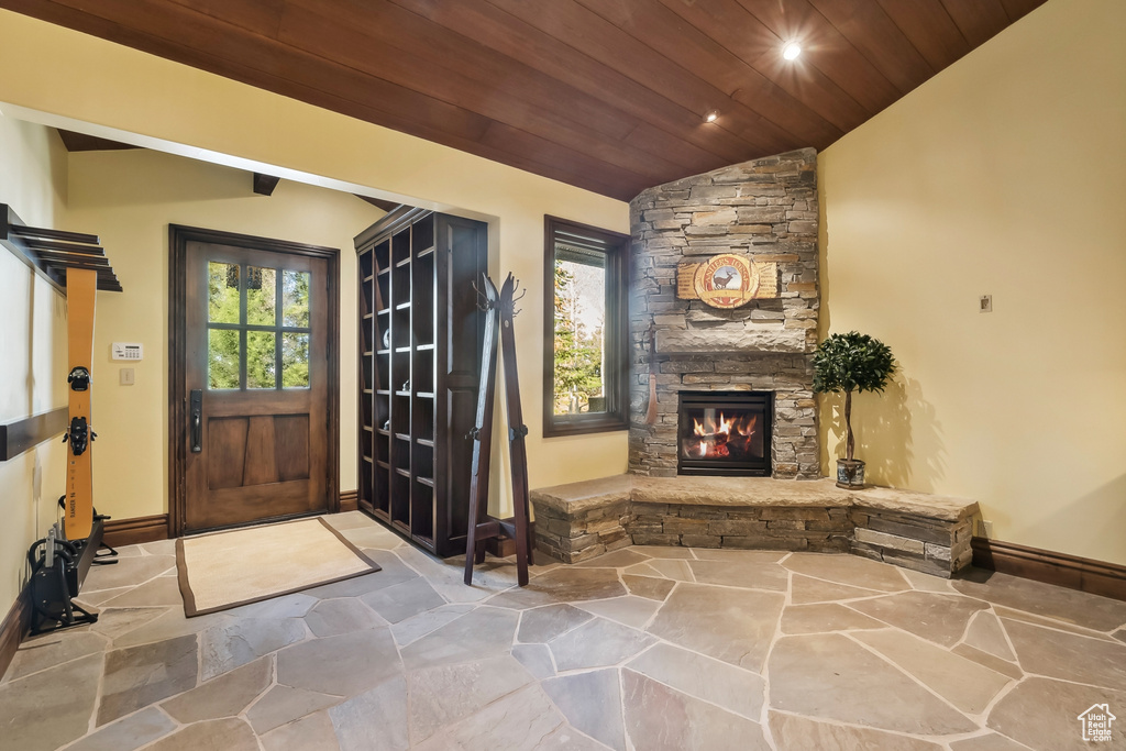 Foyer featuring vaulted ceiling, a fireplace, and wooden ceiling